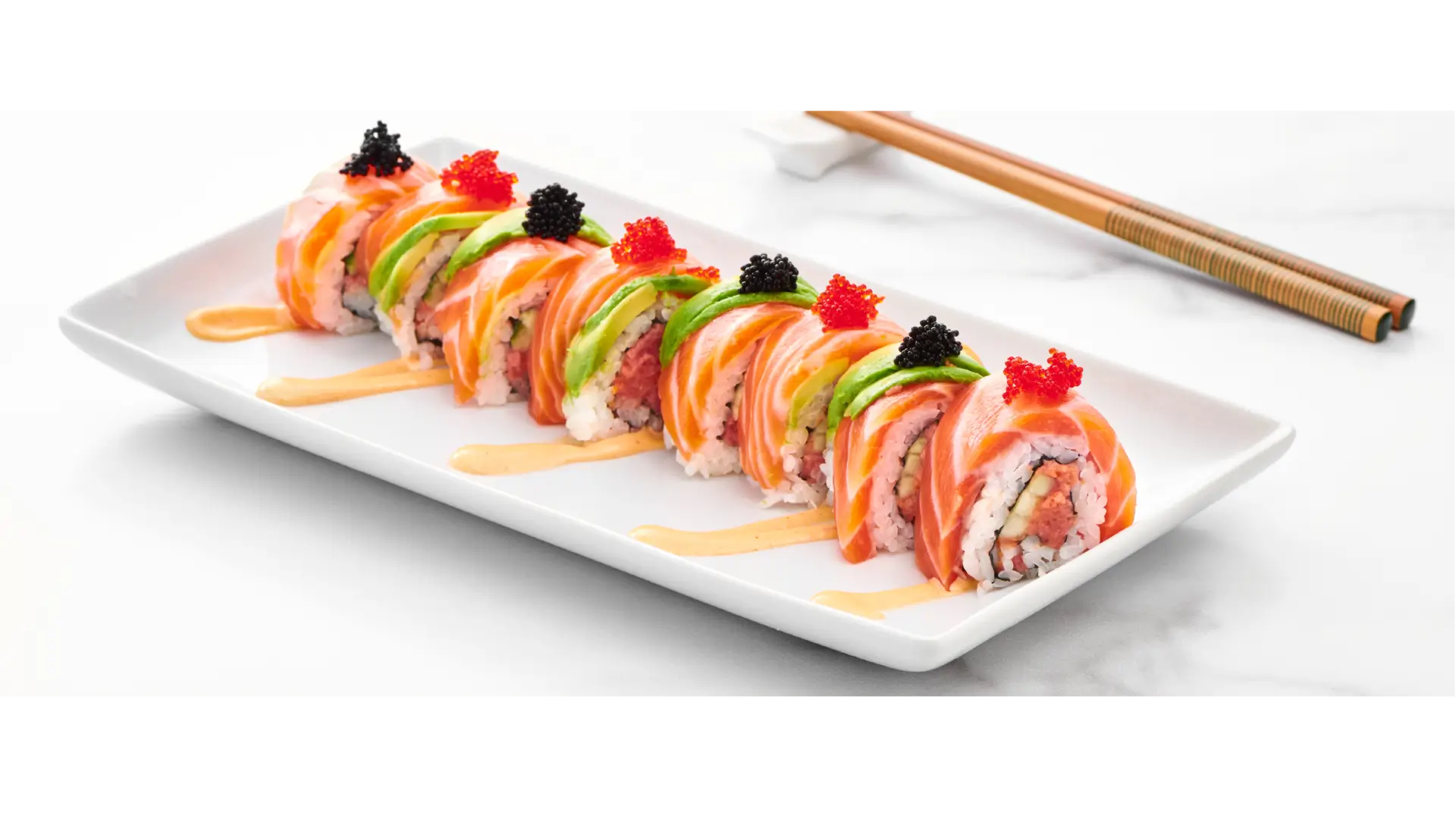 A sushi roll with many different toppings on it.